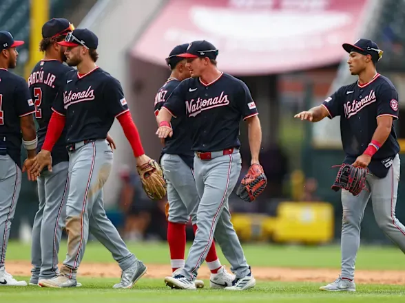 Washington Nationals players celebrate on the field after a win.