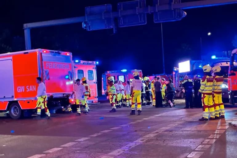 Emergency vehicles and personnel at the scene in Berlin at night.
