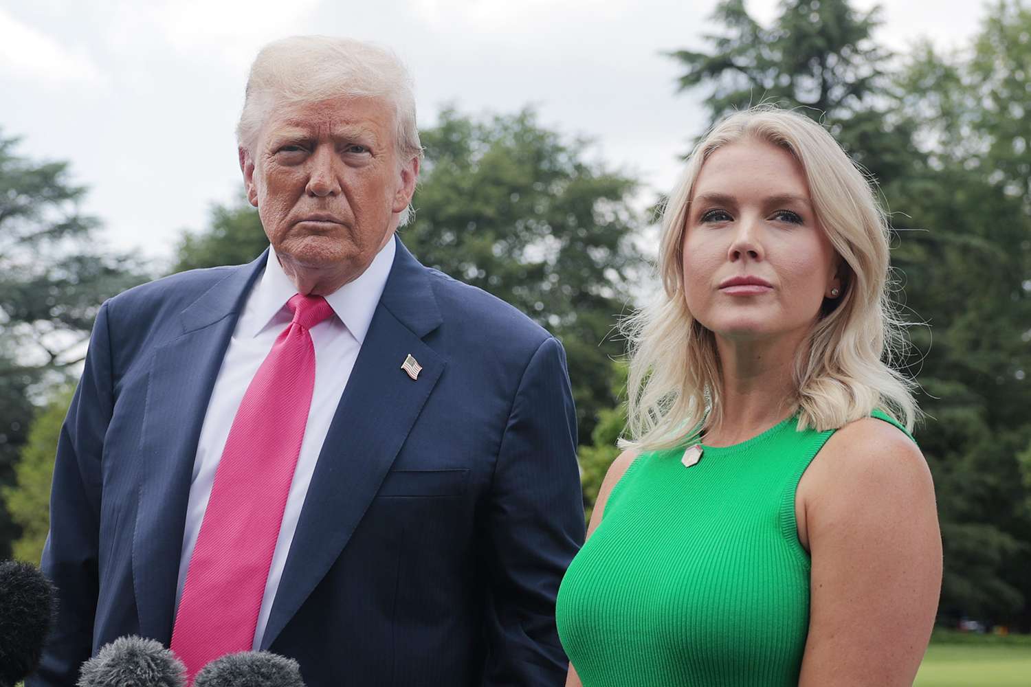 President Donald Trump standing beside White House press secretary Karoline Leavitt outdoors.