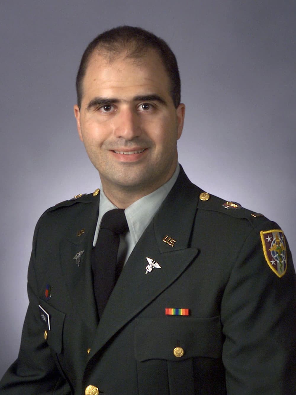 Official US Army portrait of Nidal Hasan in dress green uniform with Medical Corps insignia.