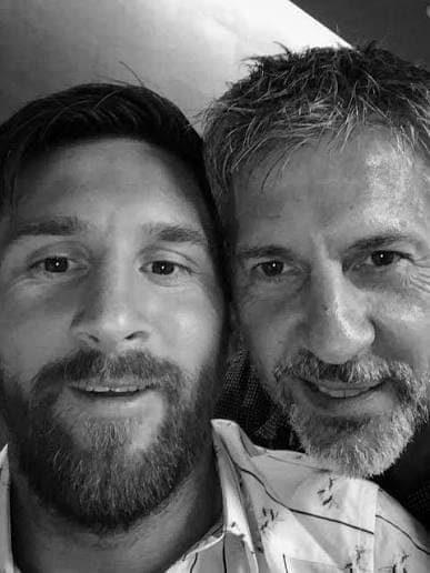 A black and white photograph of Lionel Messi and his father together.