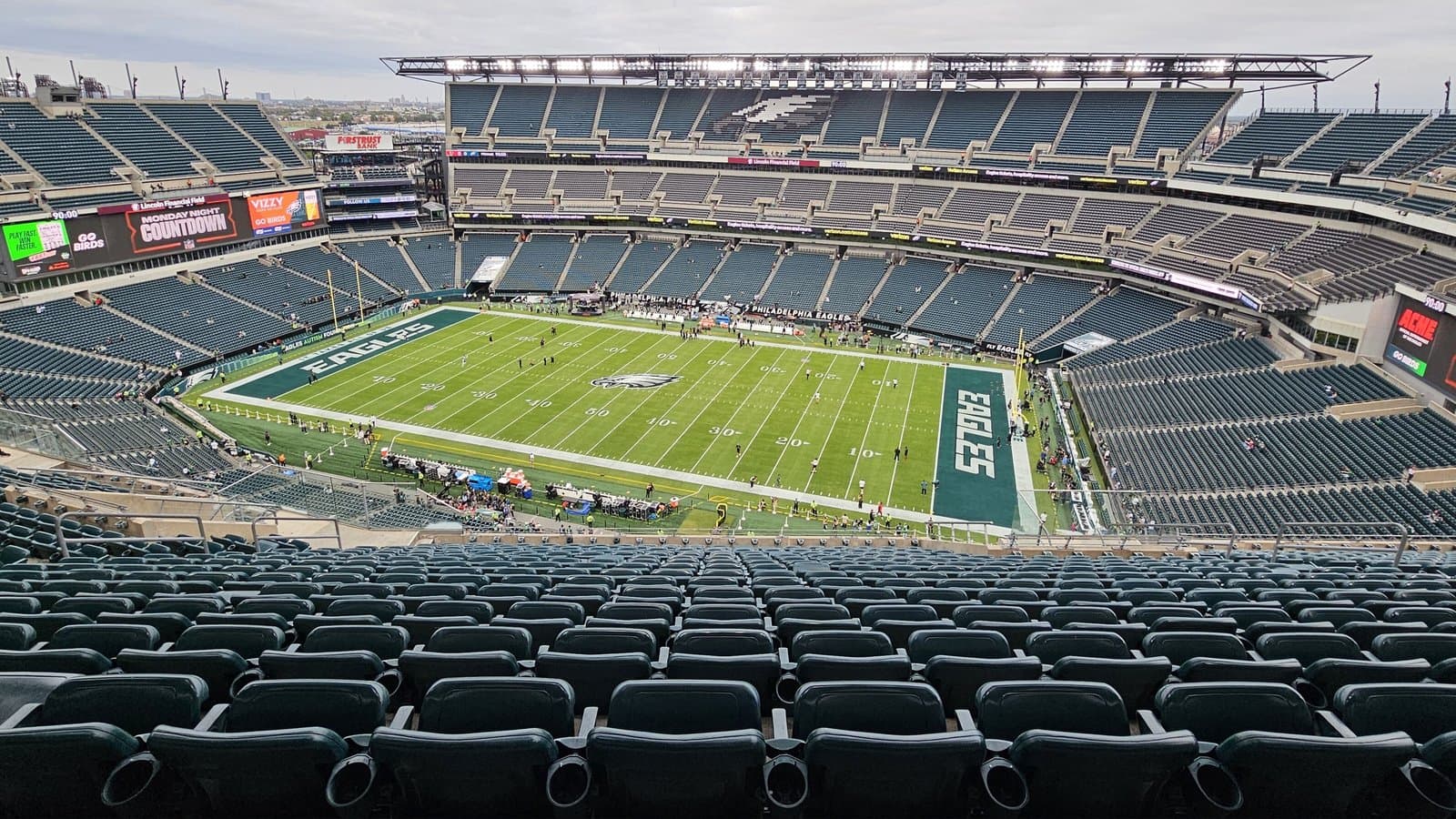 Wide view of Lincoln Financial Field from the upper deck, with green seats around the field and Eagles lettering in the end zone.