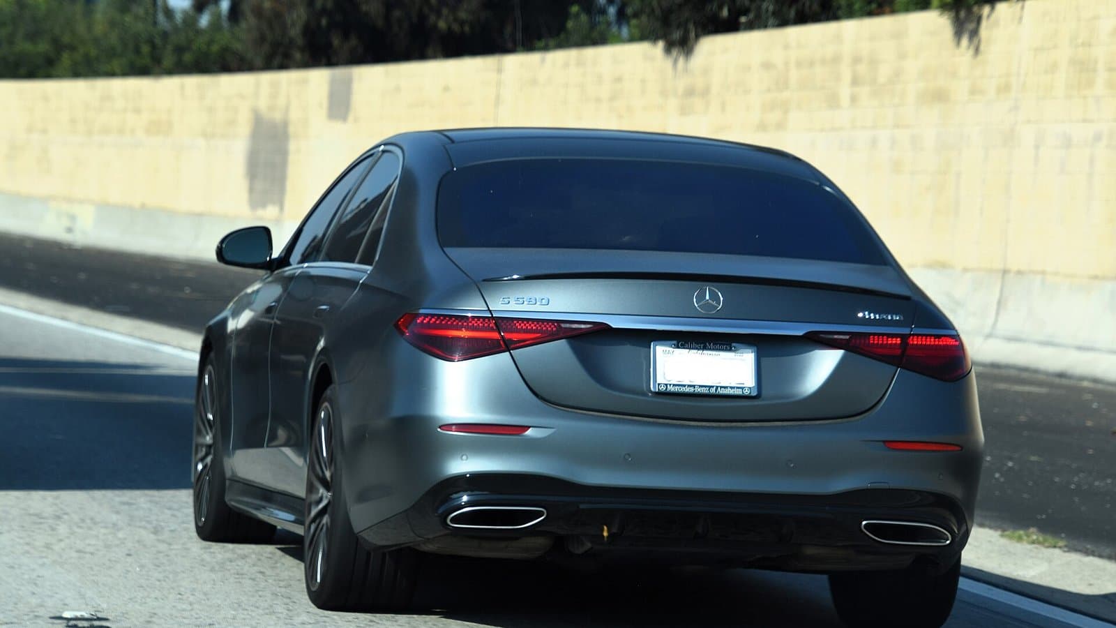 A dark gray Mercedes-Benz S 580 4MATIC luxury sedan seen from behind on a highway.