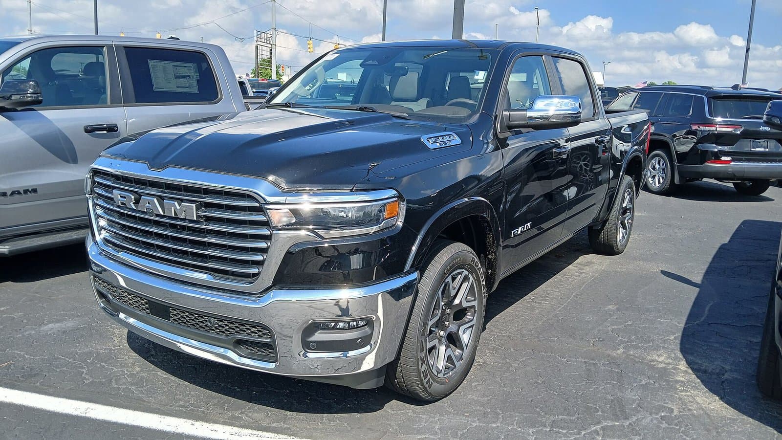 A black 2025 Ram 1500 crew cab pickup truck parked on a dealership lot, seen from the front right.