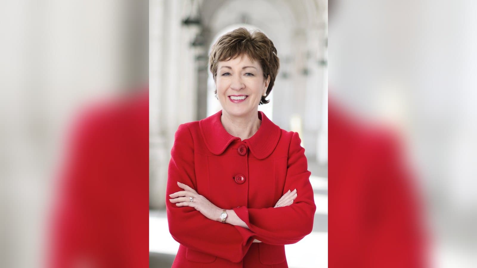 Official portrait of Senator Susan Collins in a red jacket, arms crossed and smiling, against a soft white background.