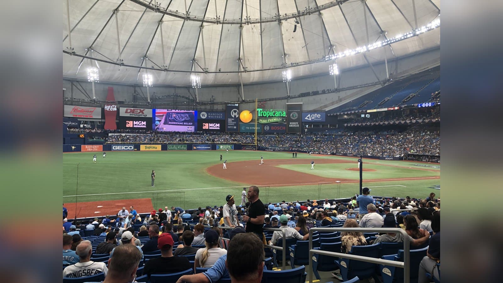 View from the stands at Tropicana Field's domed ballpark during a playoff game, with fans in the lower bowl and the infield below.