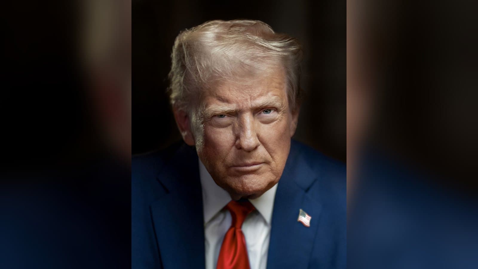 Official portrait of President Donald Trump in a dark suit and red tie with an American flag lapel pin, photographed against a dark background.