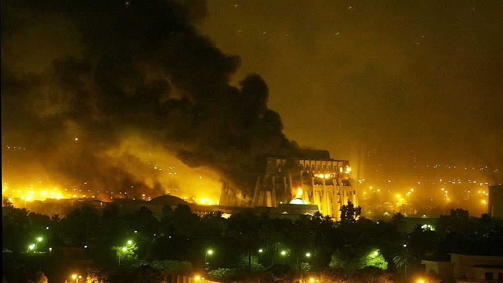 Archive photo from 2003: a large building in Baghdad burning at night under a huge plume of black smoke.