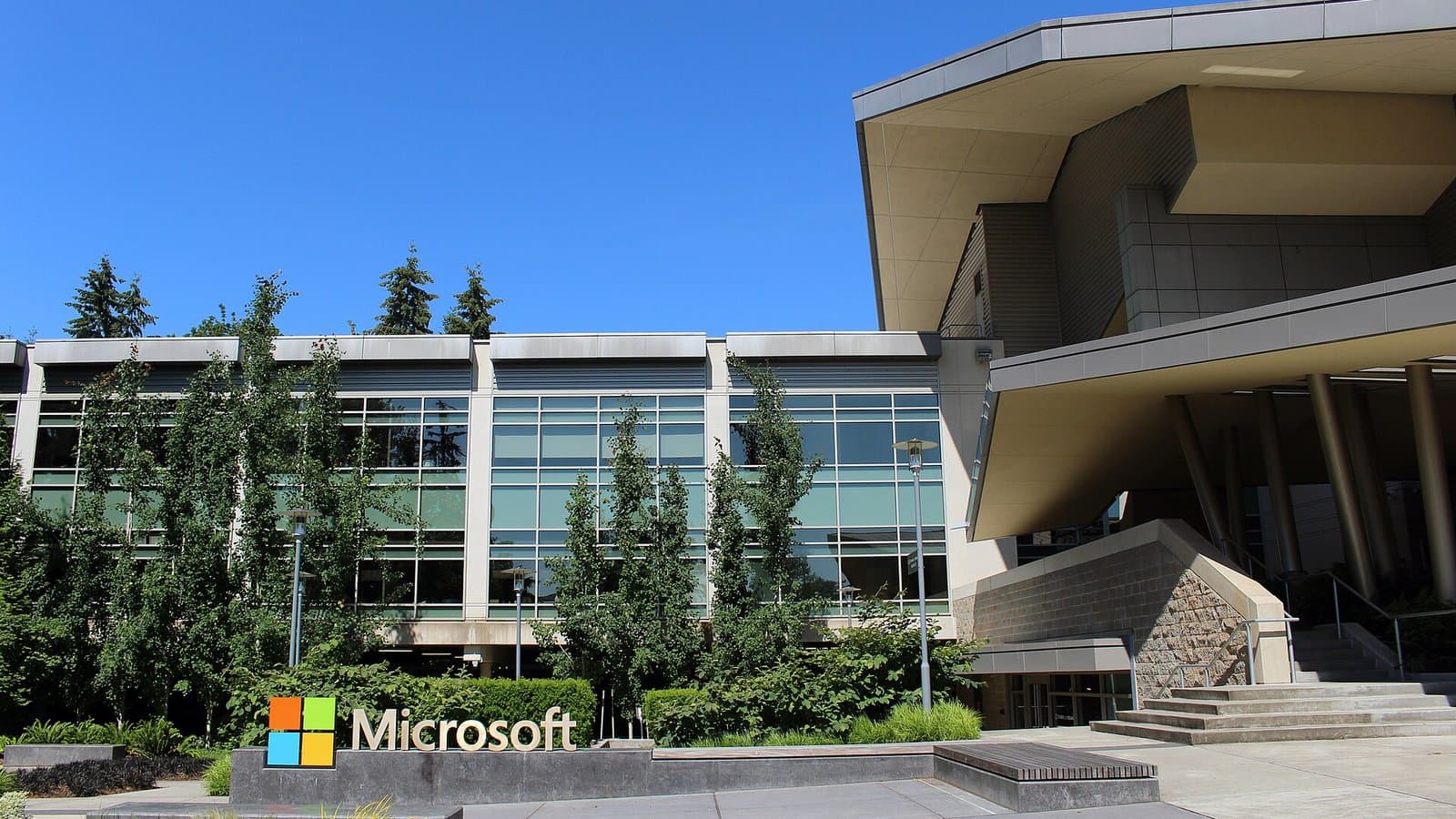 Microsoft's Building 92 visitor center in Redmond, Washington, with the Microsoft logo sign on the lawn in front.