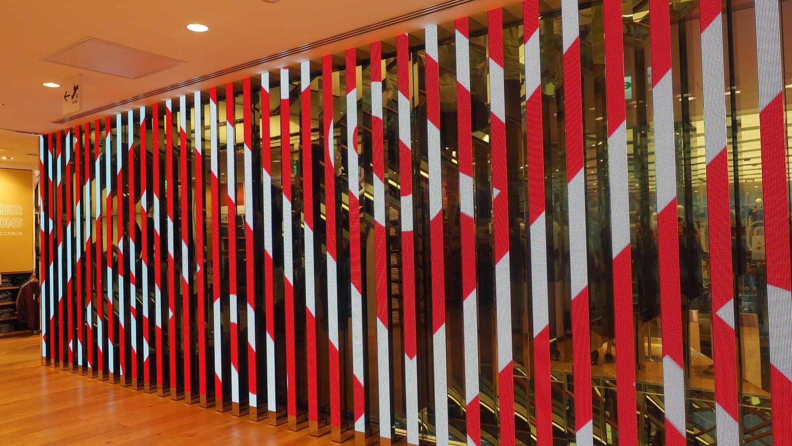 Bold red and white vertical stripes forming a large graphic wall inside UNIQLO's Ginza flagship store in Tokyo.