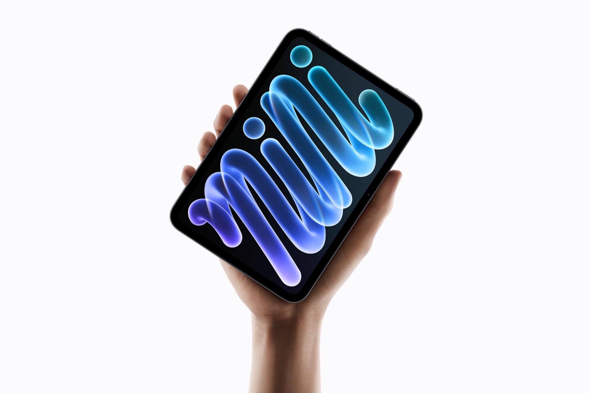 A hand holds up the new iPad mini, its OLED screen showing a glowing blue and purple 'mini' lettering against a white background