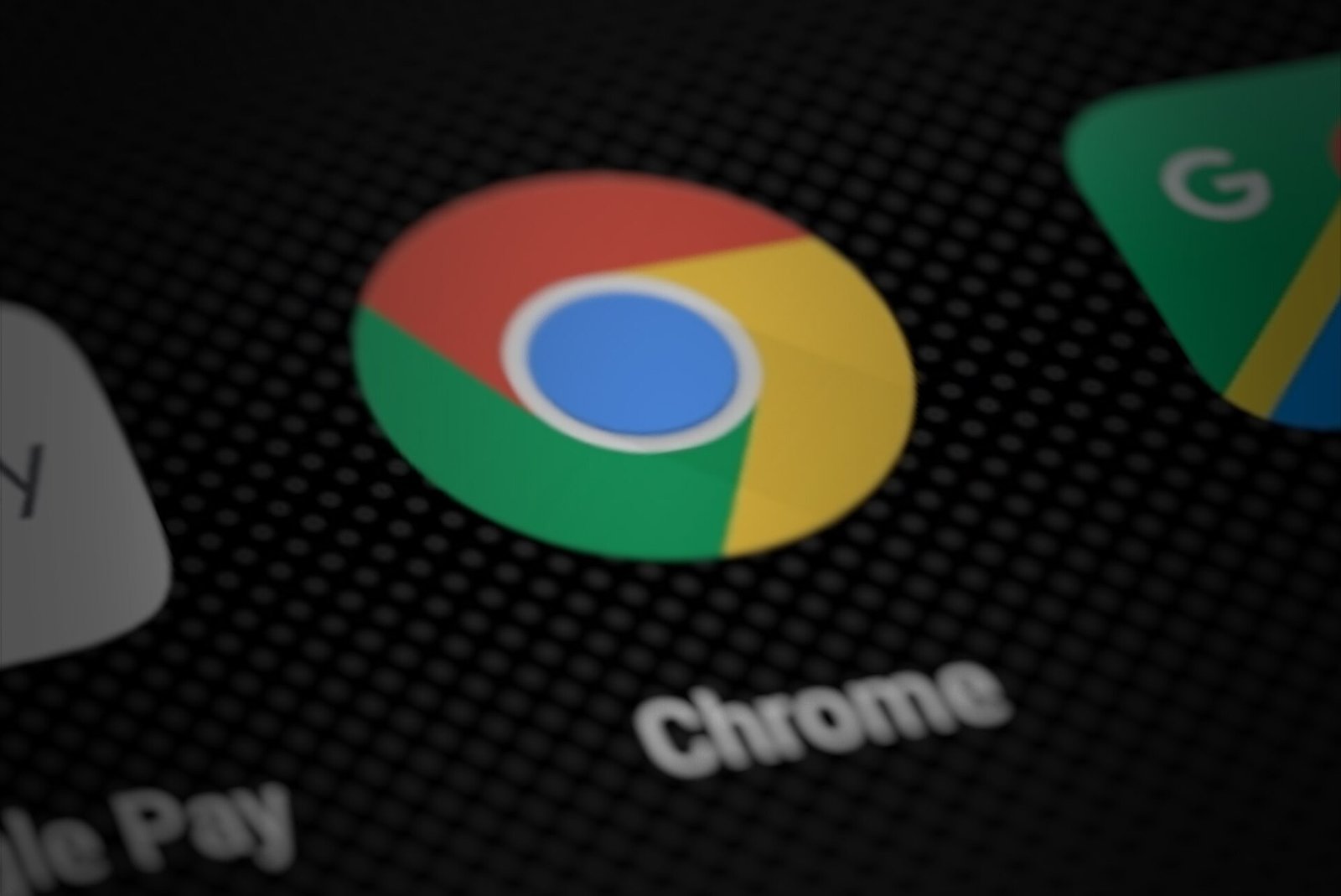 Close-up of the red, yellow, green and blue Google Chrome app icon with the word Chrome beneath it on a dark smartphone home screen.