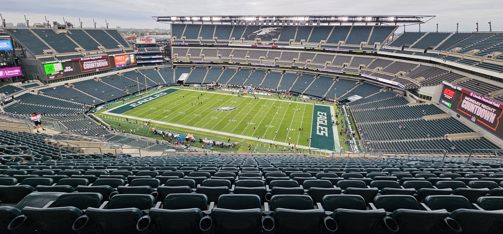 Wide view of Lincoln Financial Field from the upper deck, with green seats around the field and Eagles lettering in the end zone.
