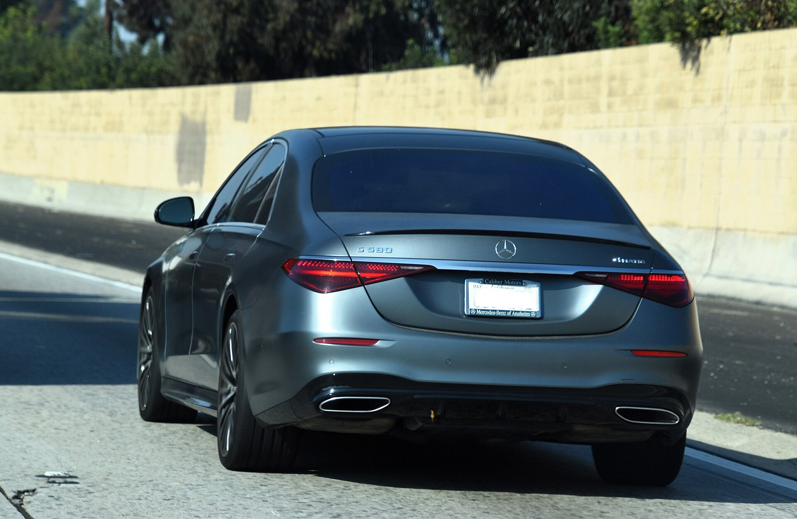 A dark gray Mercedes-Benz S 580 4MATIC luxury sedan seen from behind on a highway.