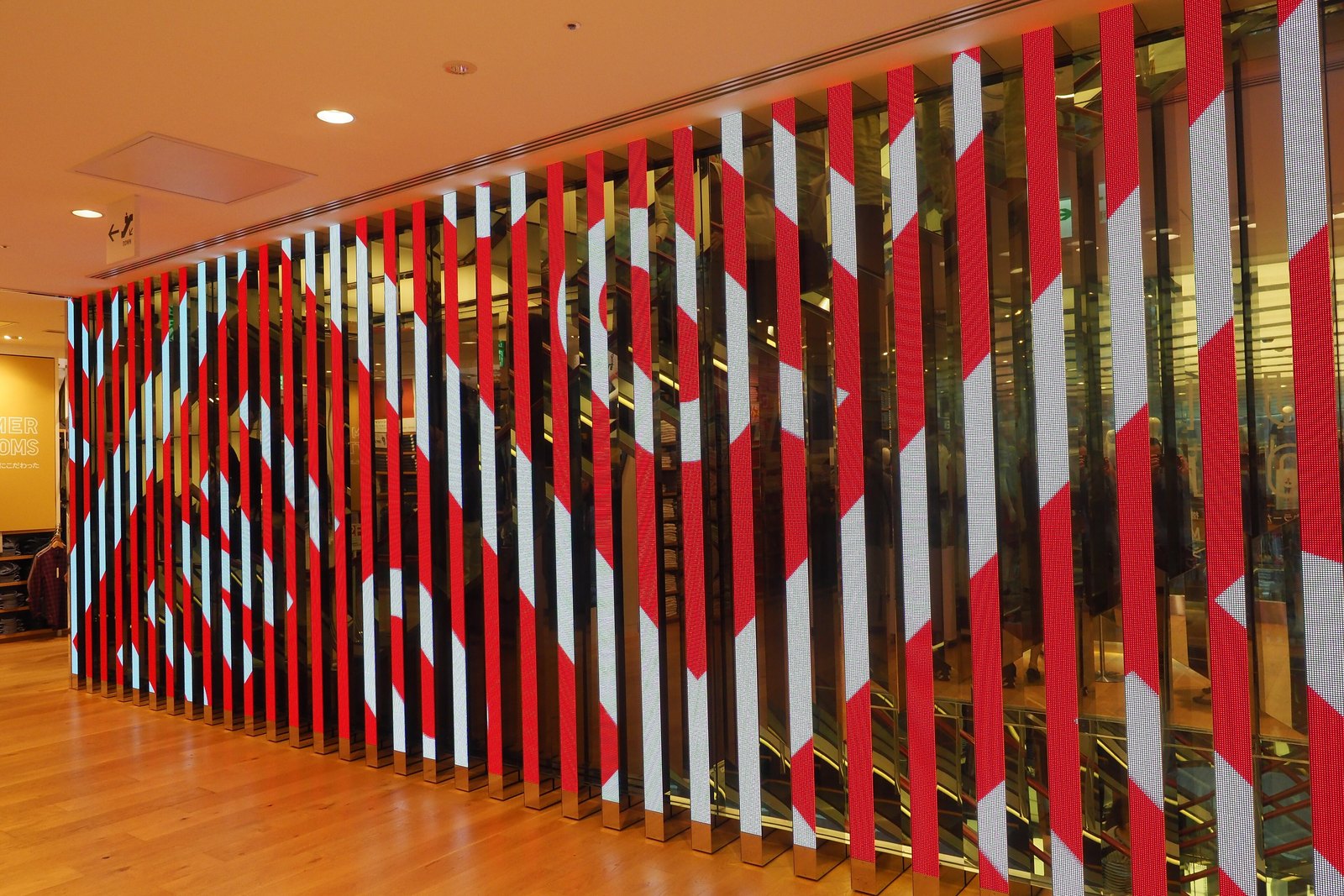 Bold red and white vertical stripes forming a large graphic wall inside UNIQLO's Ginza flagship store in Tokyo.